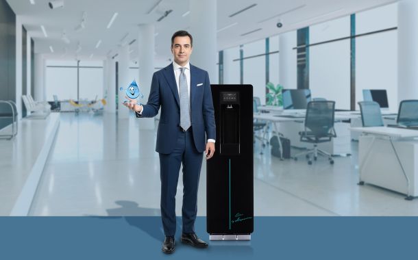 Professionista in ufficio con un erogatore di acqua Acquaviva, leader nella distribuzione di acqua in boccioni e erogatori a rete idrica, nel settore uffici e pubblica amministrazione