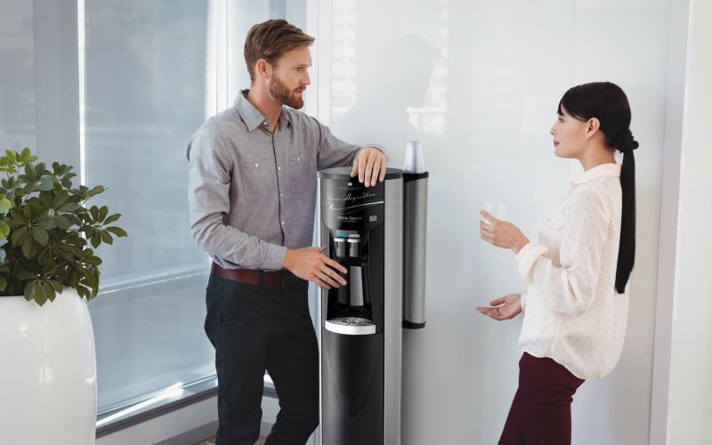 Colleghi in ufficio utilizzano l’erogatore Acquaviva a rete idrica