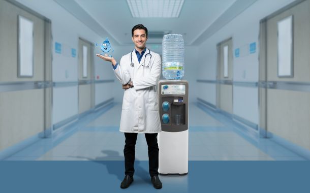 Dottore in ospedale con un erogatore di acqua Acquaviva, leader nella distribuzione di acqua in boccioni e erogatori a rete idrica, nel settore sanitario